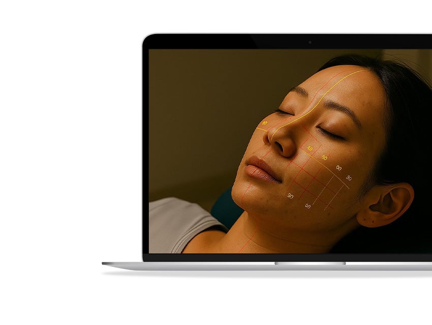 Laptop displaying an image of a woman with lines and numbers superimposed on her face.