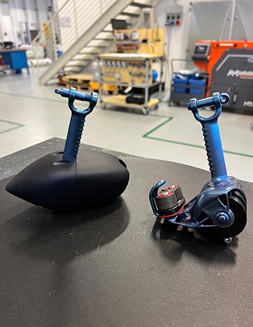 A close up of two, end-use metal 3D-printed parts that make up the catamaran's pulley system 