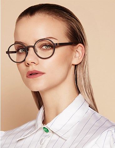 Nahaufnahme eines weiblichen Modells, das in die Kamera schaut und eine dunkle, runde BAARS SELASI-Brille trägt