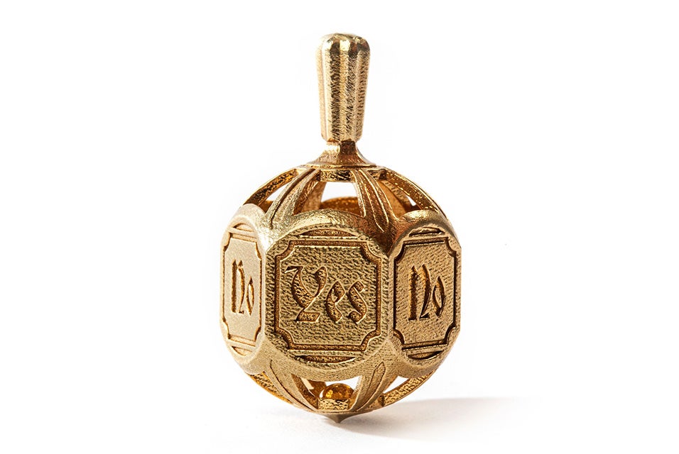 A detailed decision-making spinning top embossed with the words "yes" and "no". Made in brass using lost-wax casting.