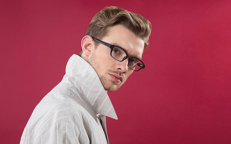 Male model in front of a red background, wearing black Hoet Cabrio Bi-Color eyeglasses