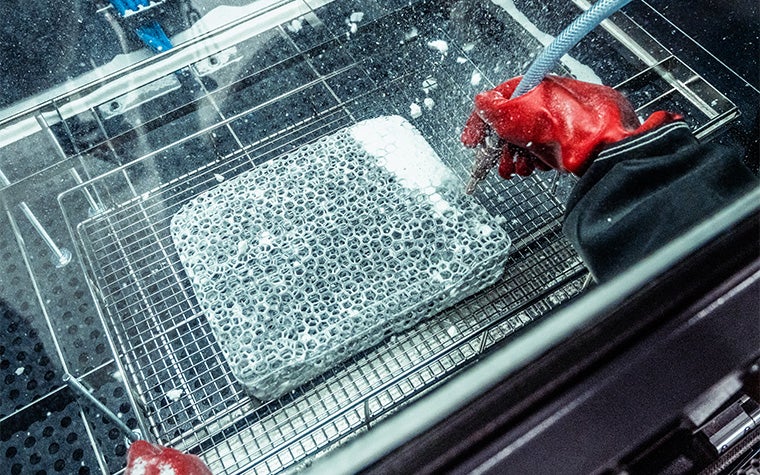 製作の後処理段階で格子デザインを清掃する人