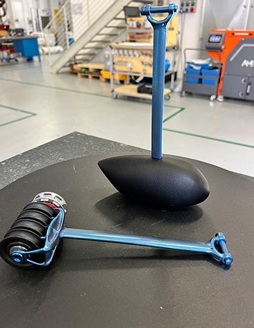 A close up of two post-processed and fnished 3D-printed parts that make up the catamaran's pulley system 