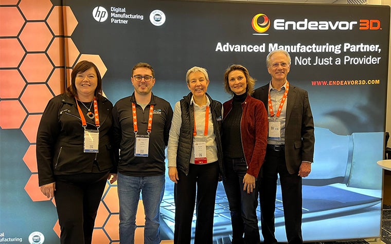 Members of Materiailse, HP, and Endeavor 3D standing in front of a back wall for Endeavor 3D at AMUG