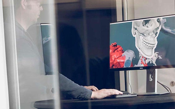 Person standing at a desk, using medical software