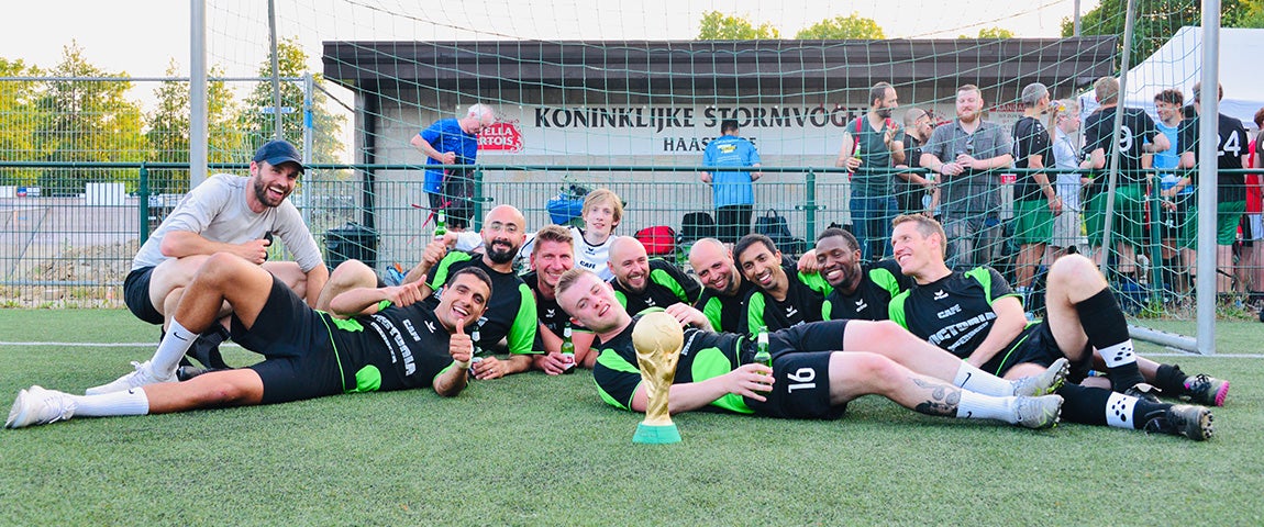 Materialise HQ soccer team posing in front of a net