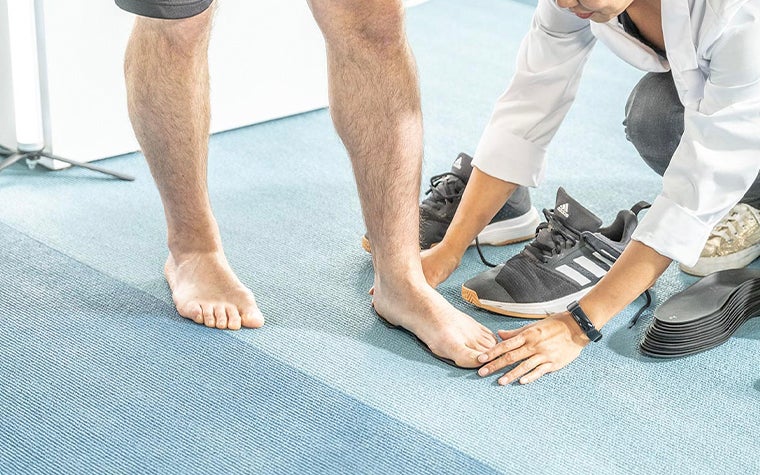 Doctor crouched down to inspect a patient's foot