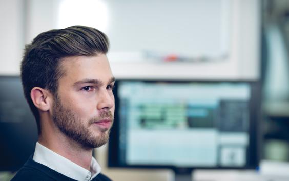 Man looking away from a screen with Streamics on it