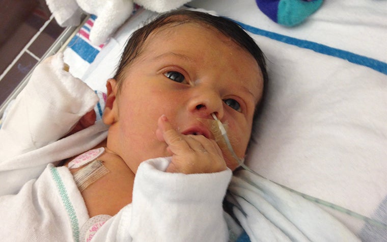 Baby lying in small hospital bed 
