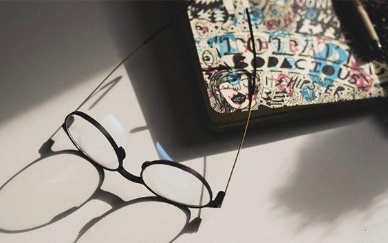 Eyeglasses on a design with a shadow extending from them