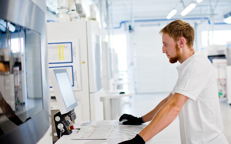 Man in a 3D printing production facility, using a computer