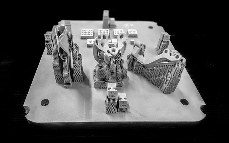 3D-printed metal parts shown with their support structure  