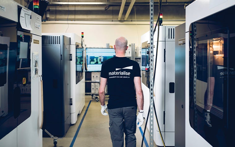 A man walking through a 3D printing facility