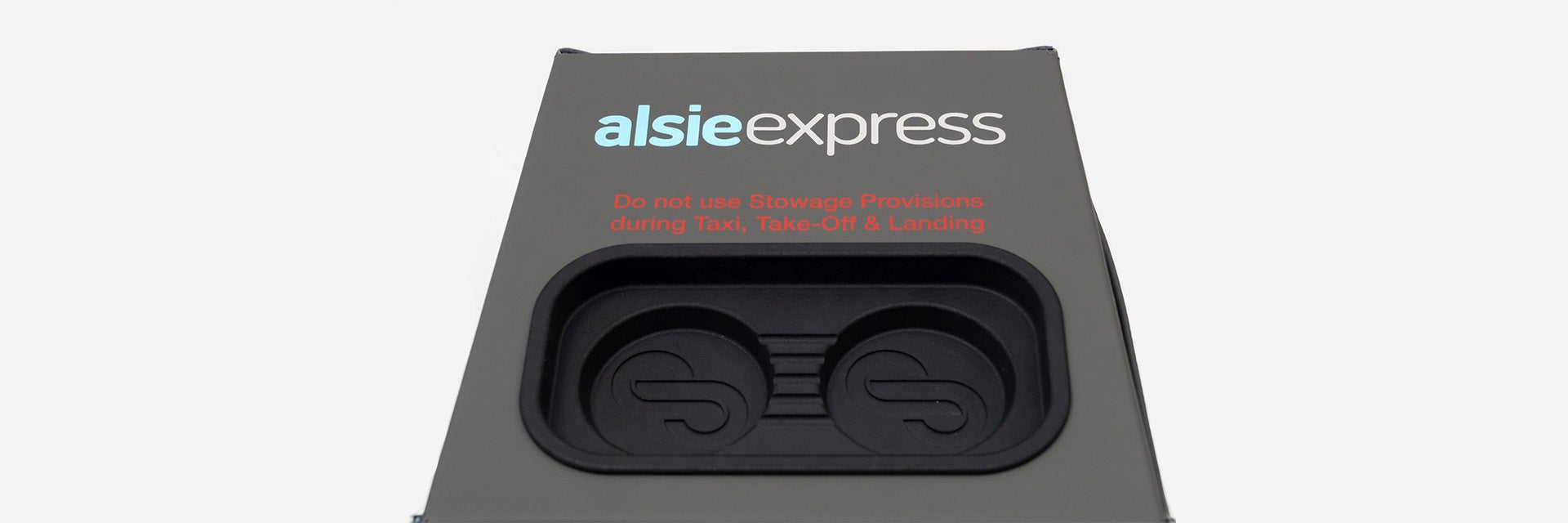 Il sistema occupa-sedile a forma di cubo di Stirling Dynamic, con pelle grigio/verde lavorata a mano e un inserto nero stampato in 3D sul lato superiore per smartphone e altri dispositivi.