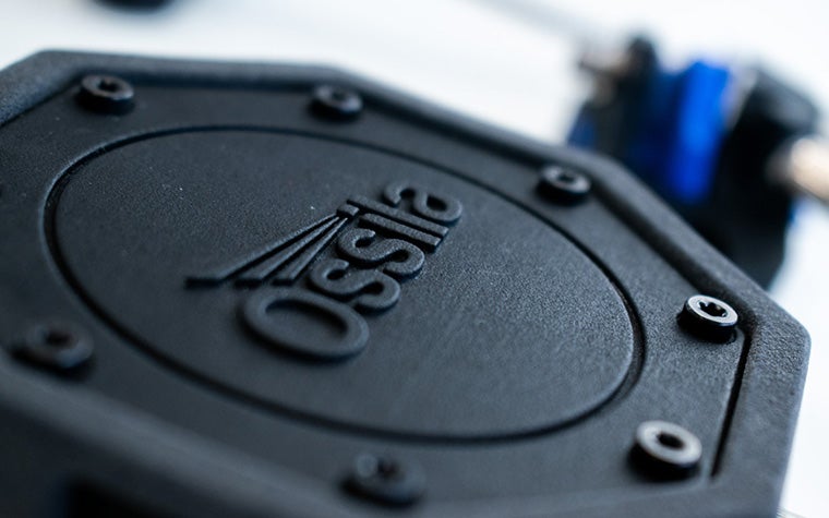 A close-up of Ossila's black 3D-printed spectrometer with the company name embossed on the surface.