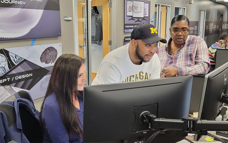A man and two women working in front of a PC screen in a Materialise office in the USA