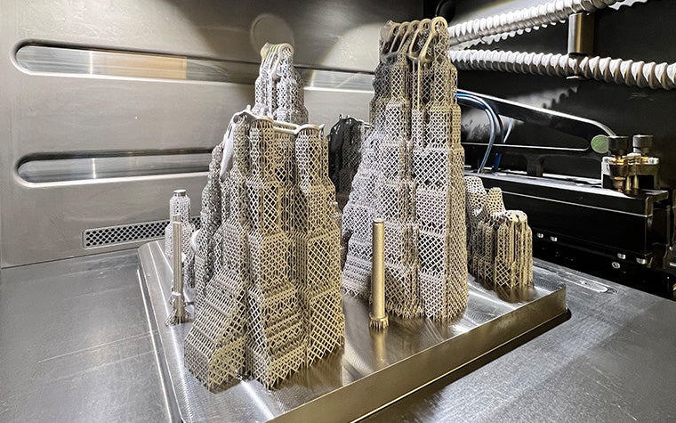 A picture of the metal build plate and 3D-printed parts being supported by needle-thin support structures generated by e-Stage for Metal+