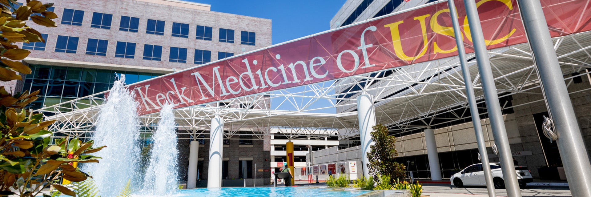 A banner say "Keck Medicine of USC," hanging above a fountain in front of the center's building