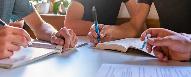 Hände mit Stiften in der Hand