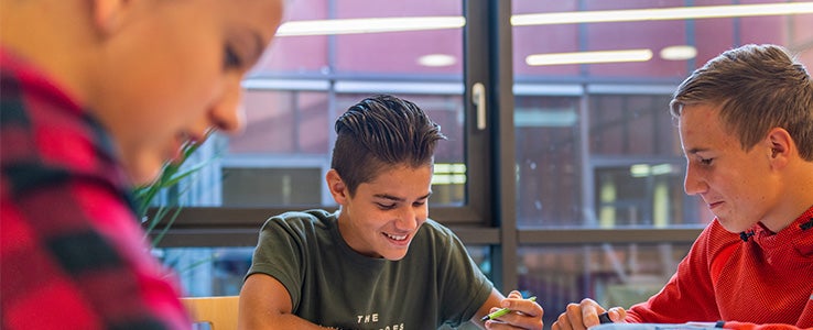 Glückliche Schüler beim Lernen im neuem Schulgebäude