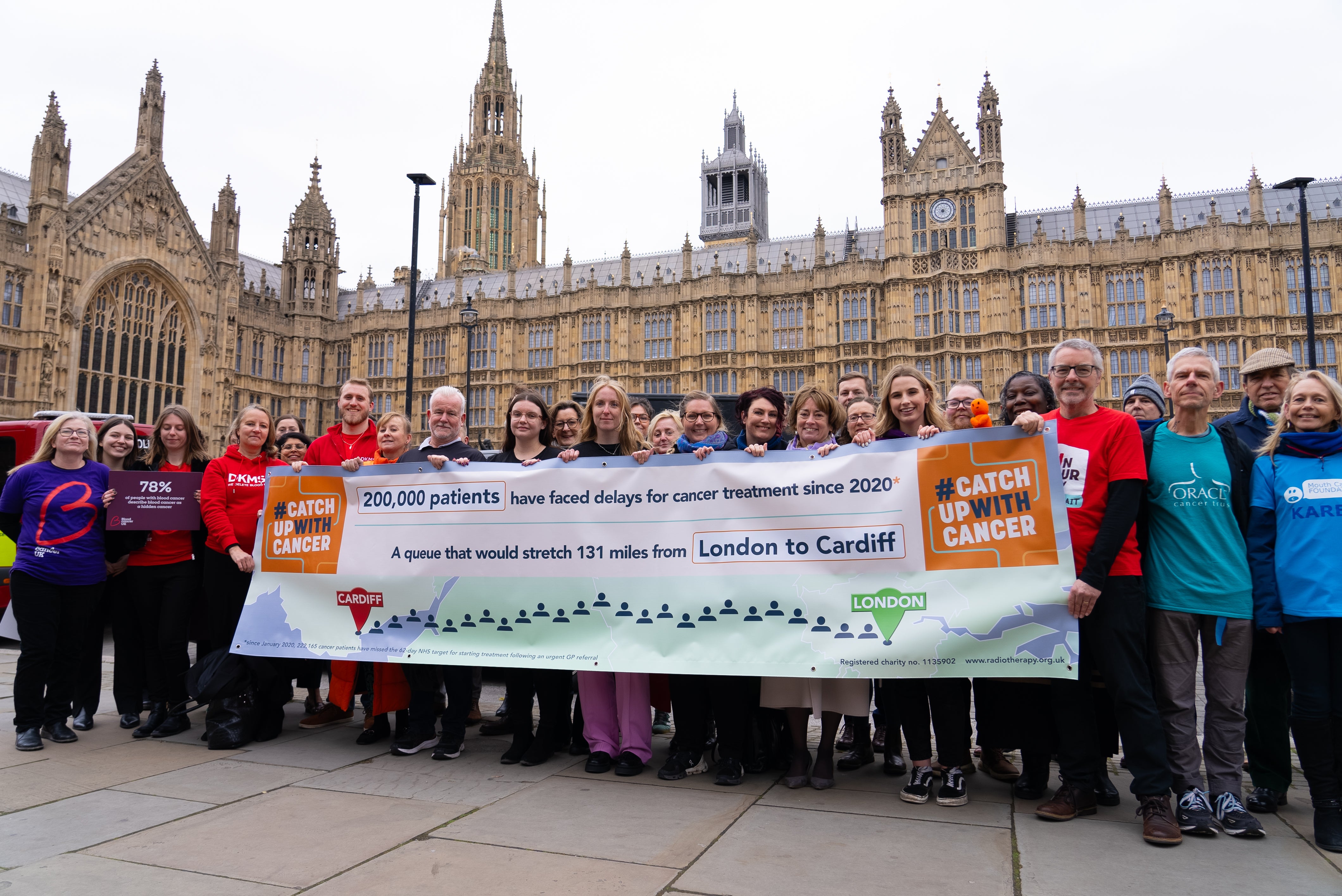 Participant at the catch up with cancer event smiling and holding up a banner