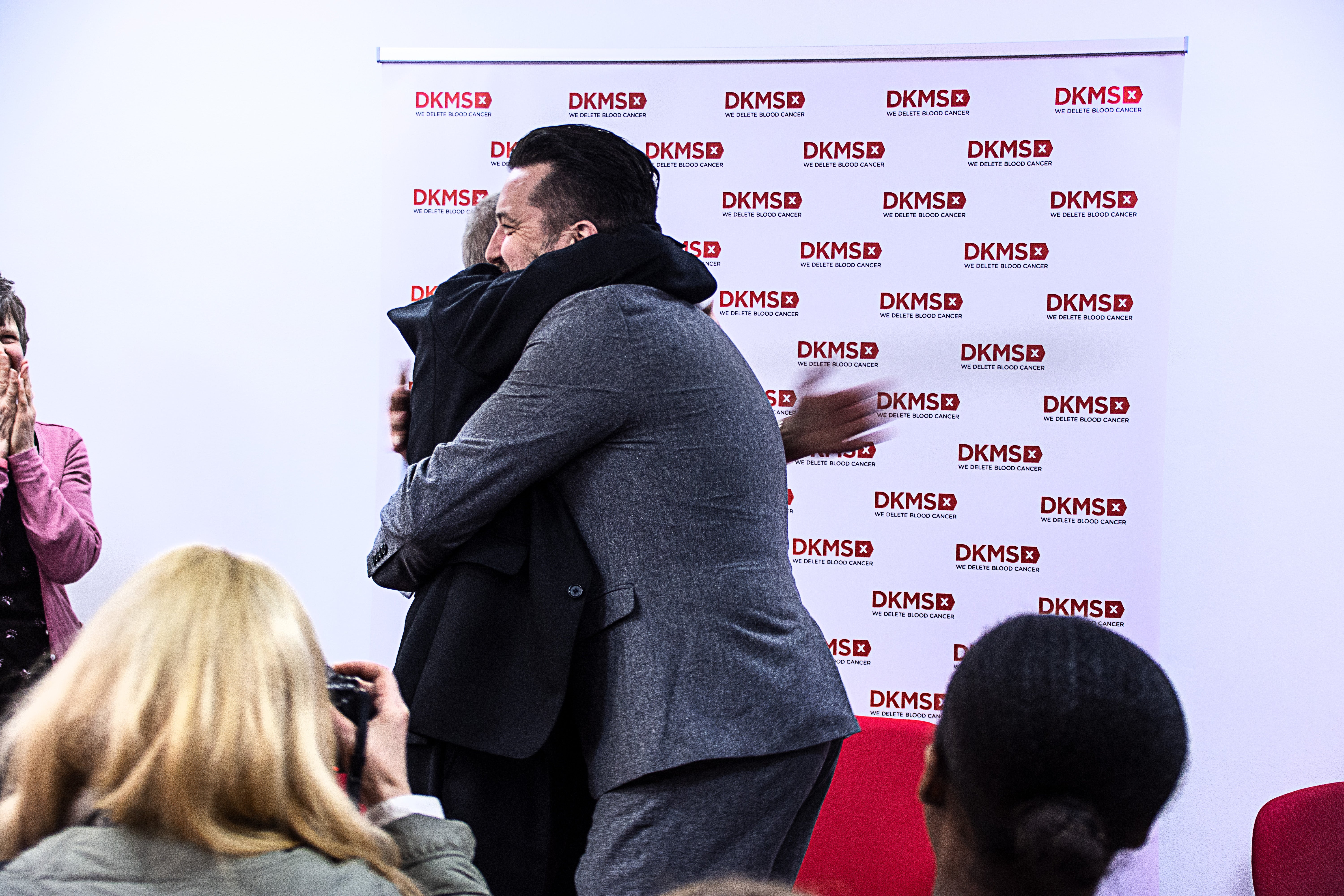 Ivor Godfrey Davies and Mark Jones hugging at DKMS UK office