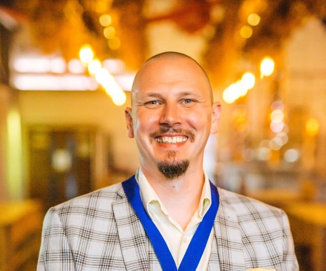 A photo of a middle aged white man smiling at the camera