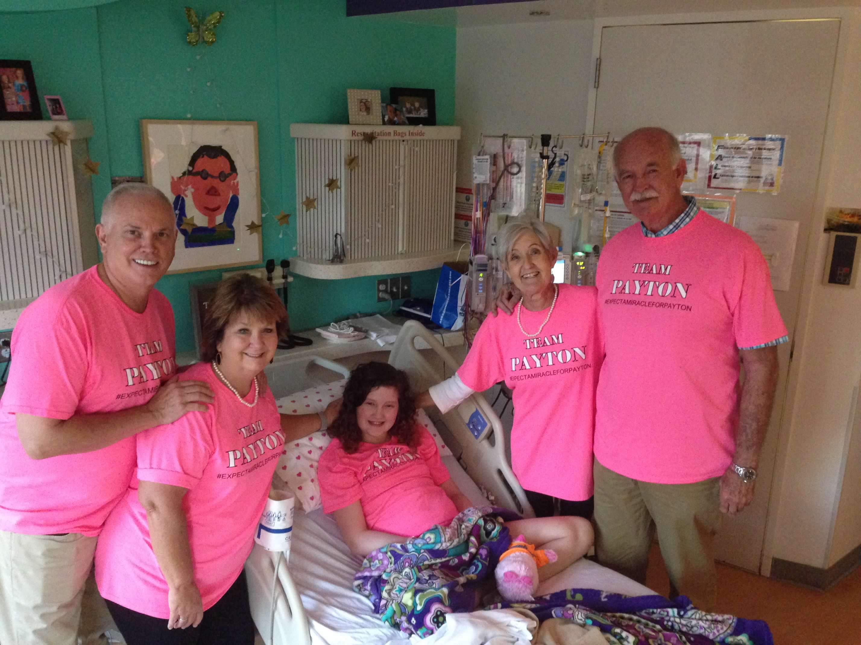 Payton on a hospital bed surrounded by her family