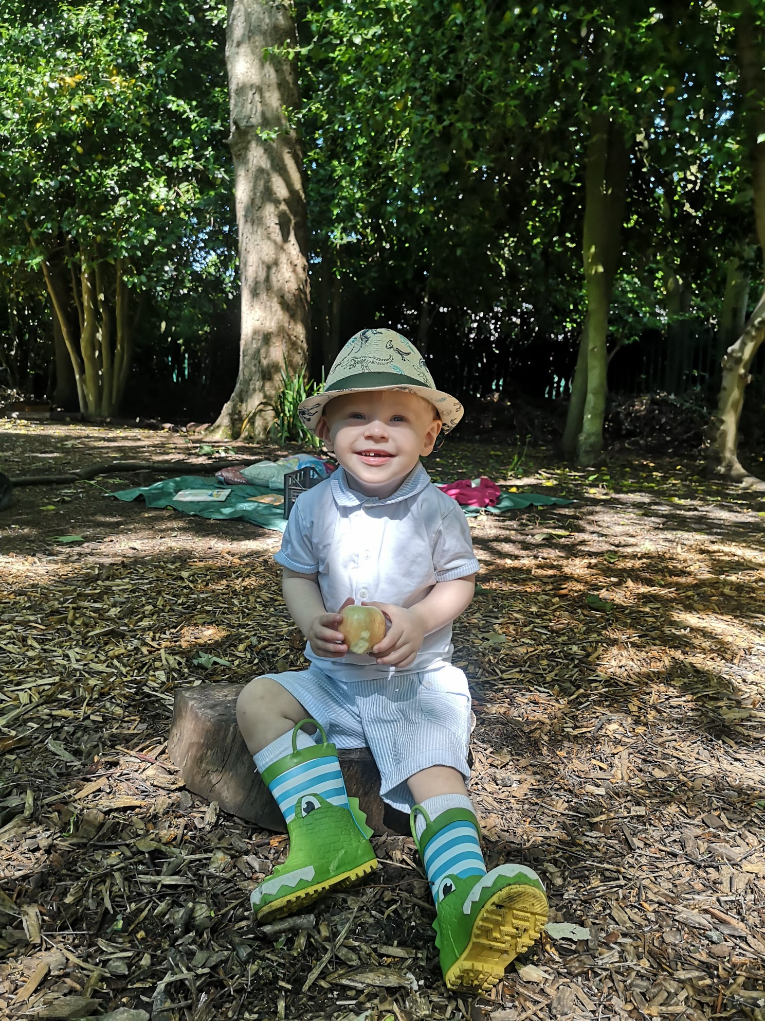 Oliver sitting on the ground in woodland