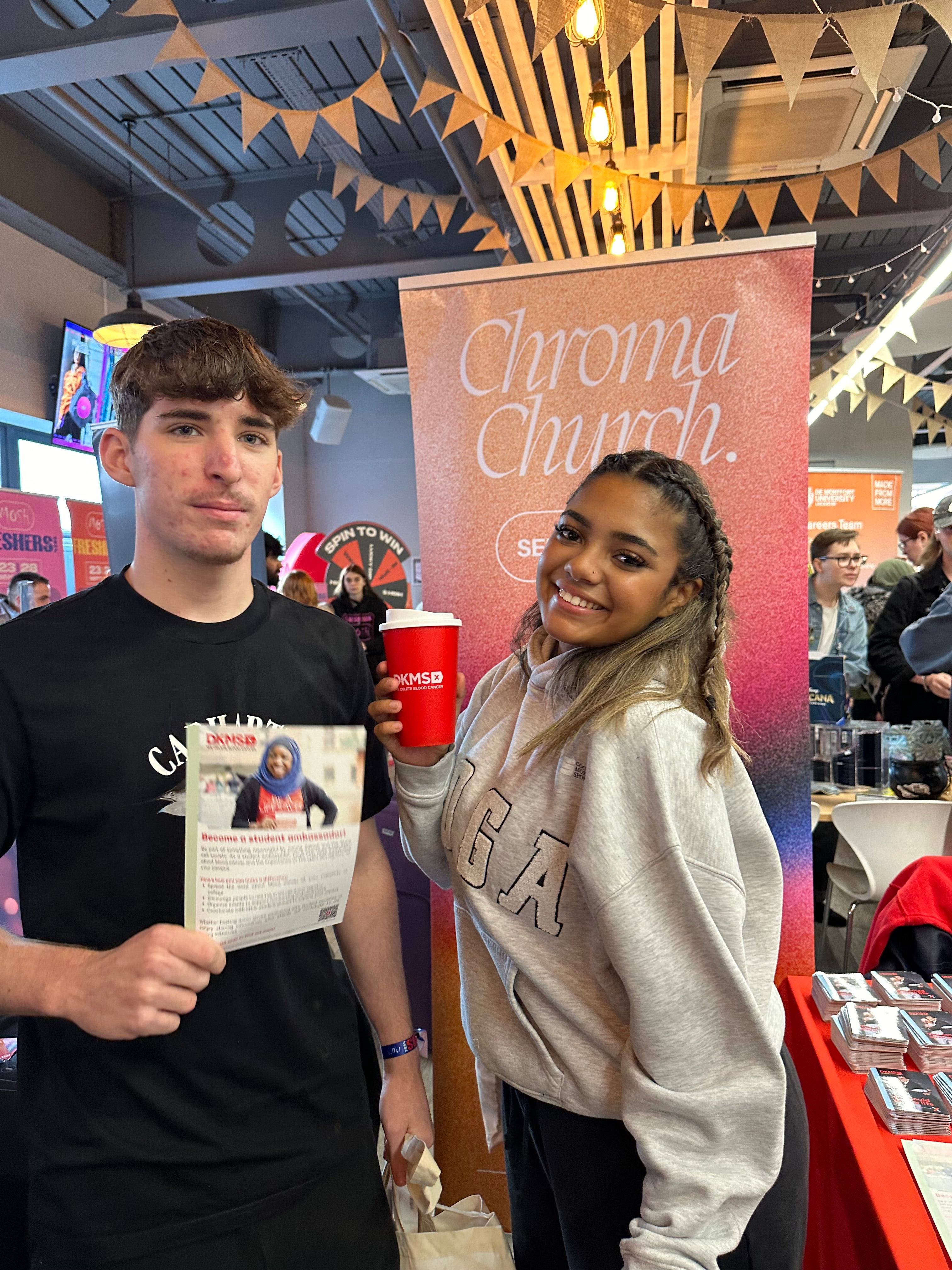 Young boy and girl smiling at DKMS registration stand