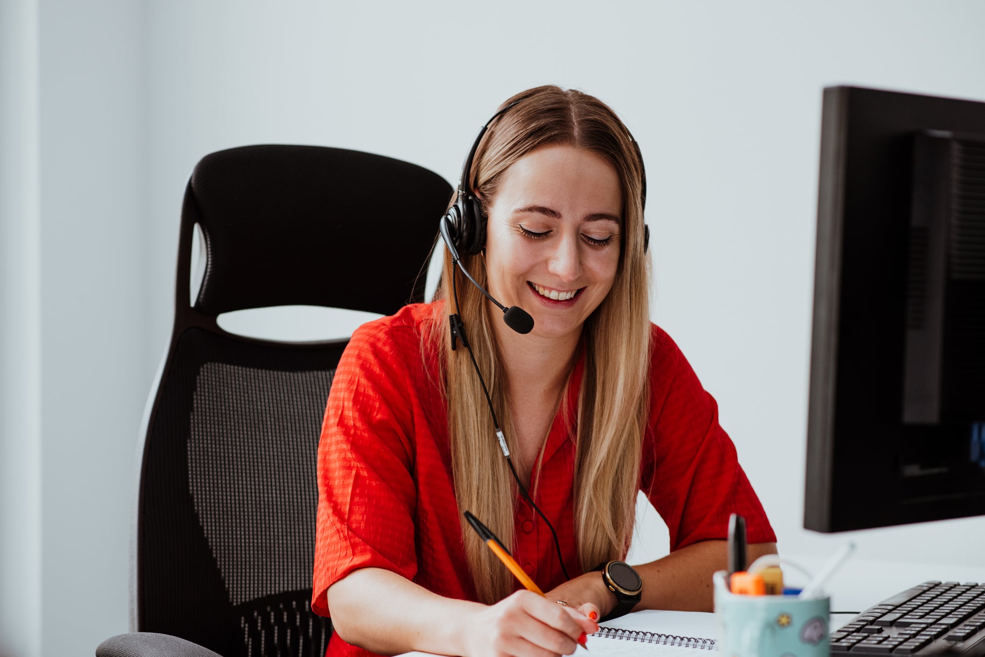 Person wearing a headset taking notes