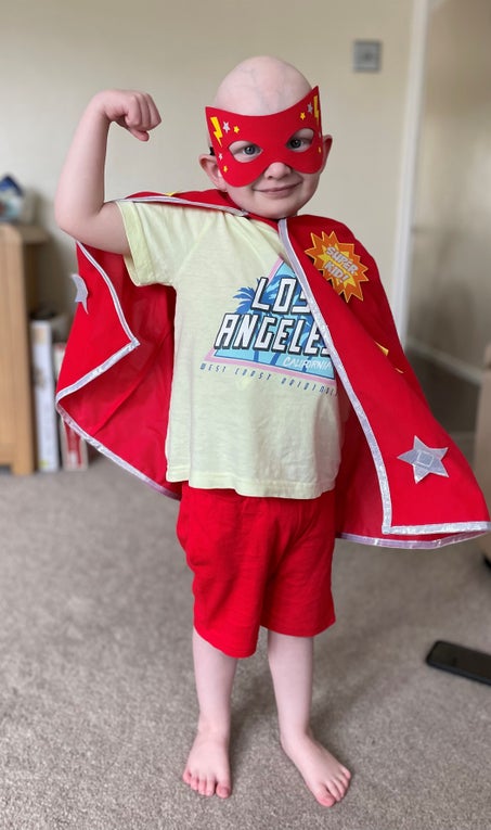 Joe dressed in 'The Flash' red superhero cape and mask