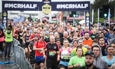 Runners crossing the start line of the Manchester Half
