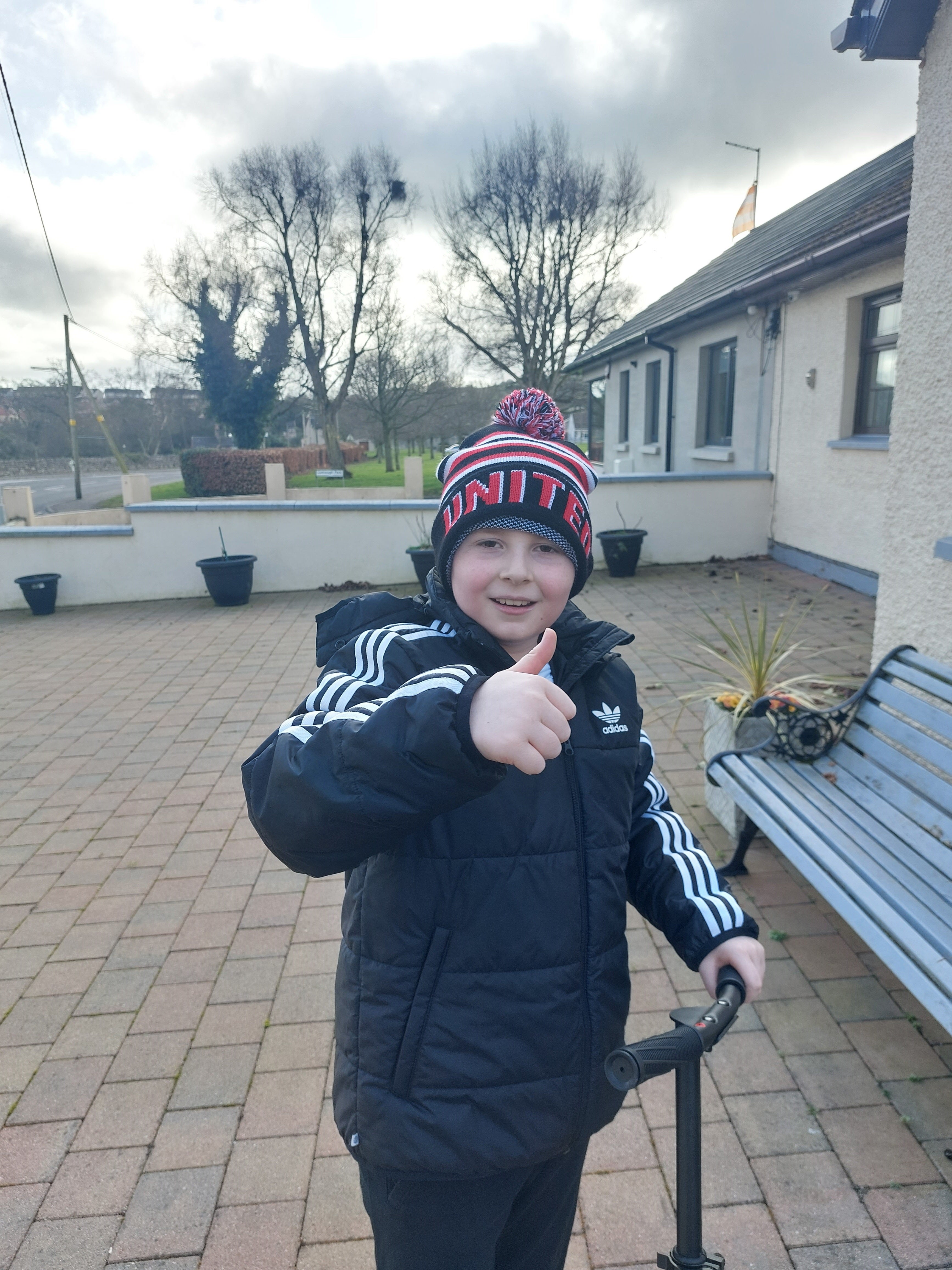 Bobby standing on a patio giving a thumb's up