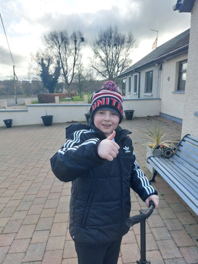 Bobby standing on a patio giving a thumb's up