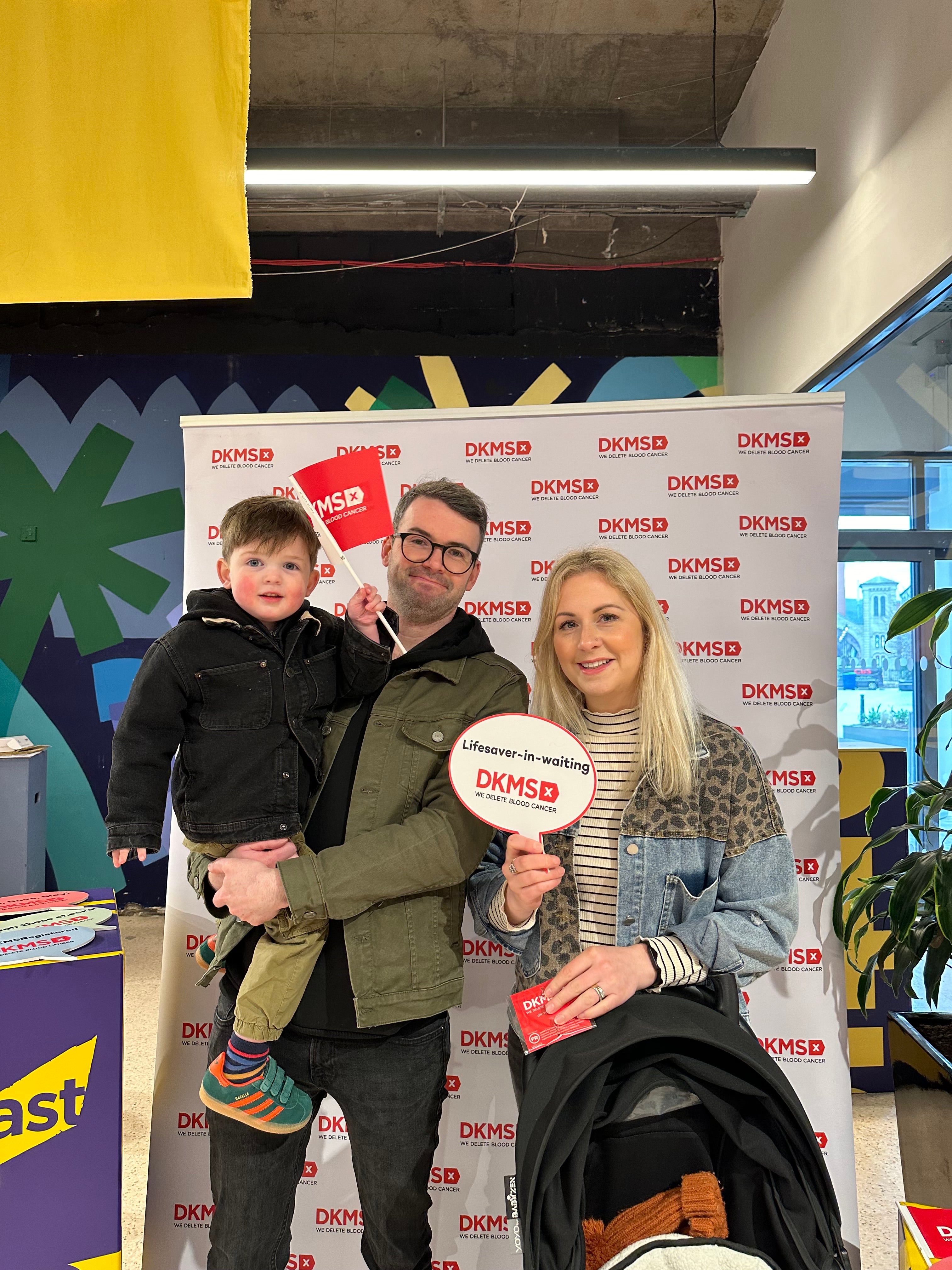 A couple and their baby smiling at a DKMS event