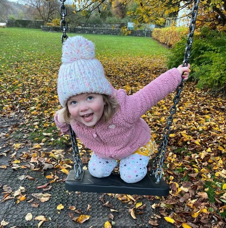 Image of Erin playing on the swings 