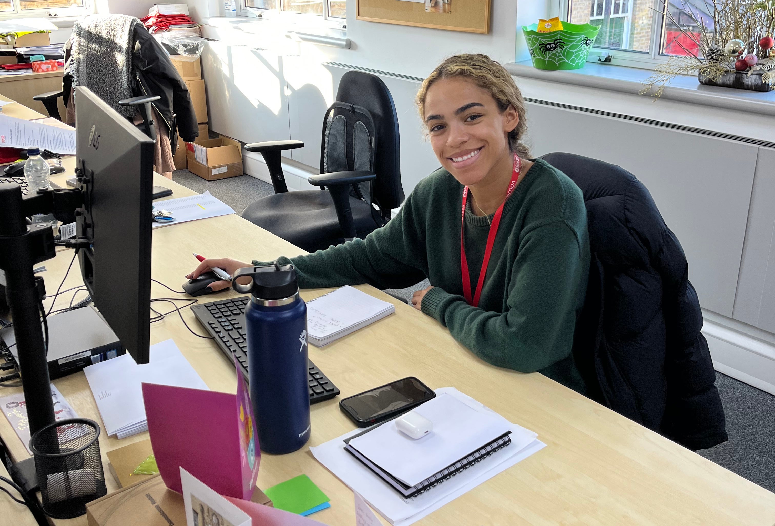 Volunteer sat at a desk in the DKMS office