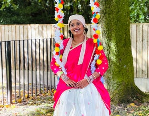 Rafiya wearing a pink and white dress sitting on a swing