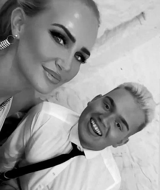 A black and white photo of a young white man and woman smiling