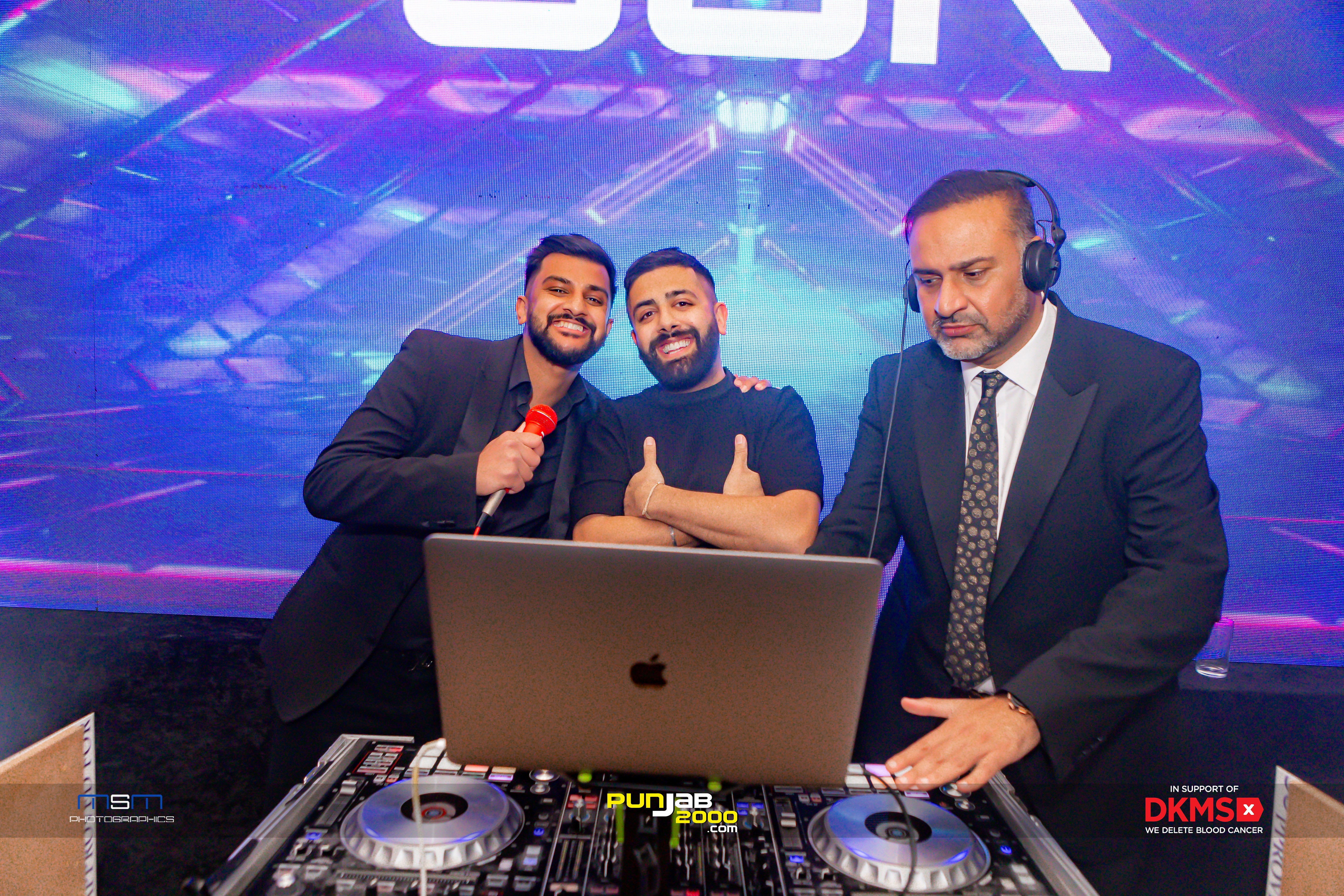 Three guests posing at a mixing desk