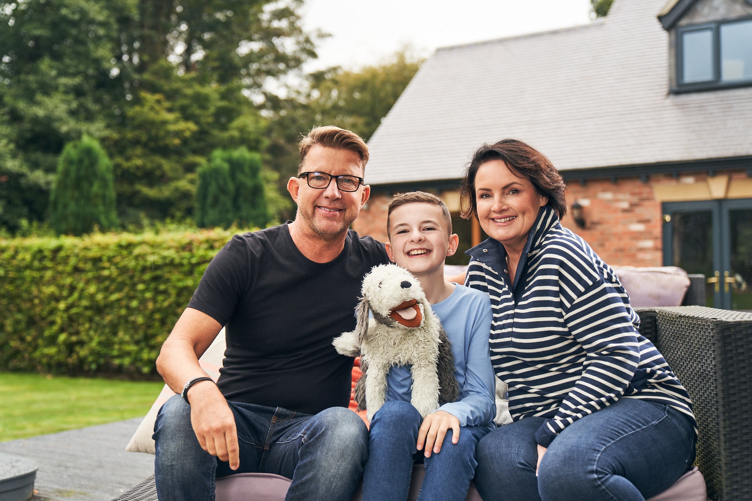 Finn with his parents, Paul and Jo, sitting in their garden
