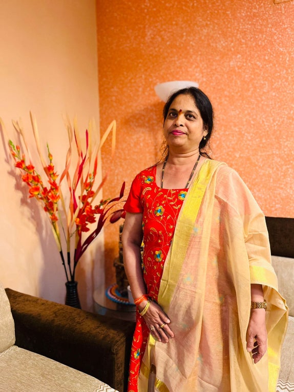 Aparna wearing a yellow and orange sari 