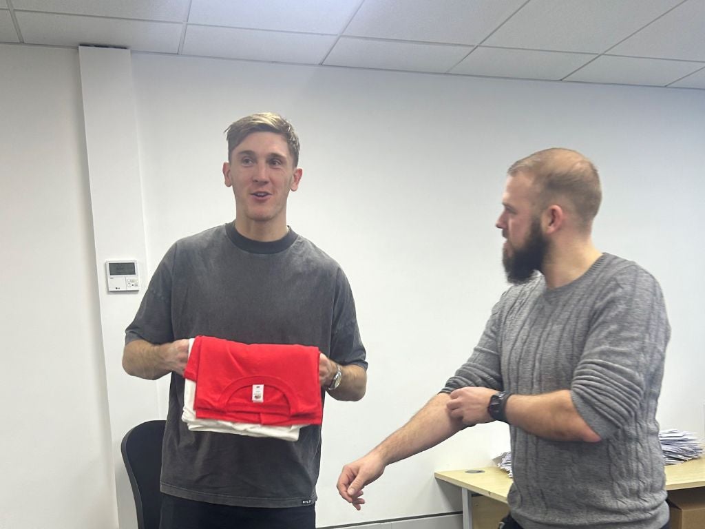 Jimmy Dunne smiling with DKMS staff holding T-shirts