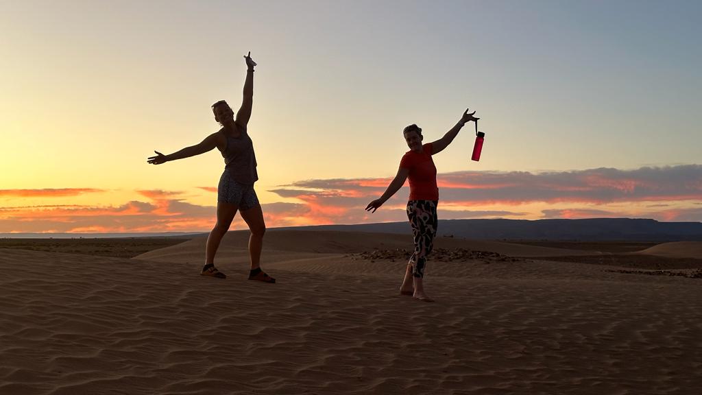 Two people at sunset in the Sahara