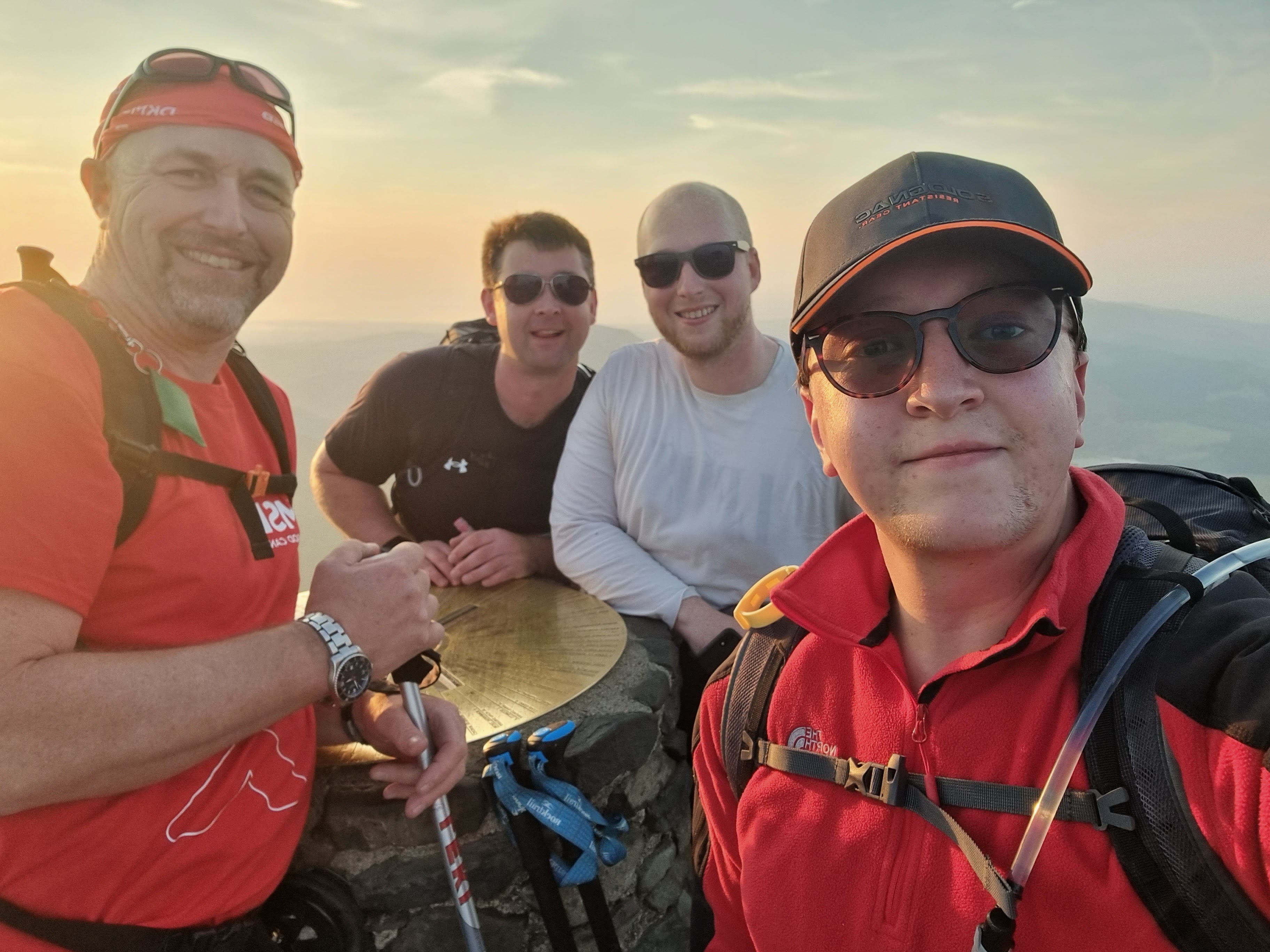 Four Chasetown staff on th mountain top beside the Yr Wyddfa (Snowdon) summit marker