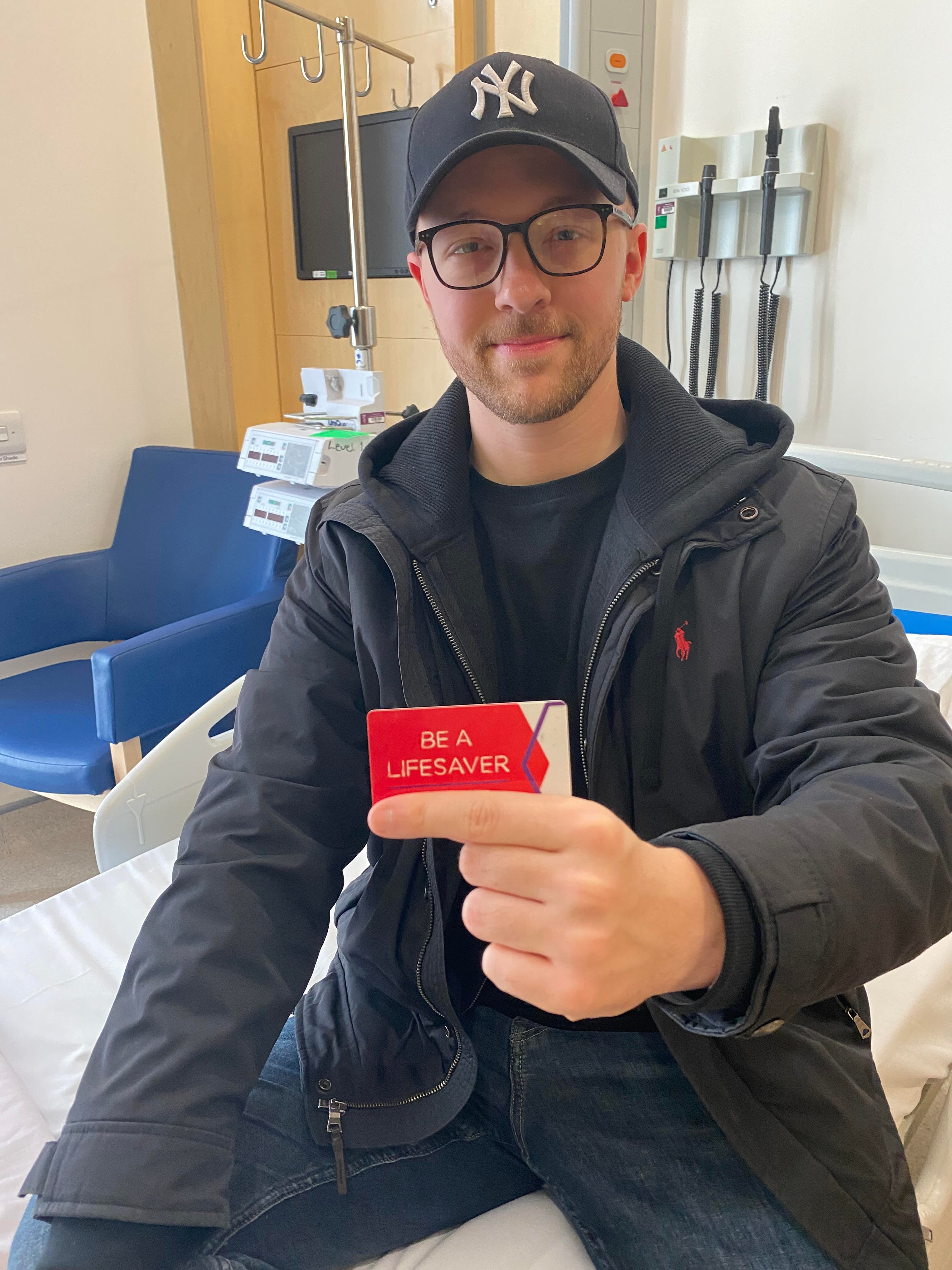 Ehan post donation holding his 'Be a Lifesaver' donor's card
