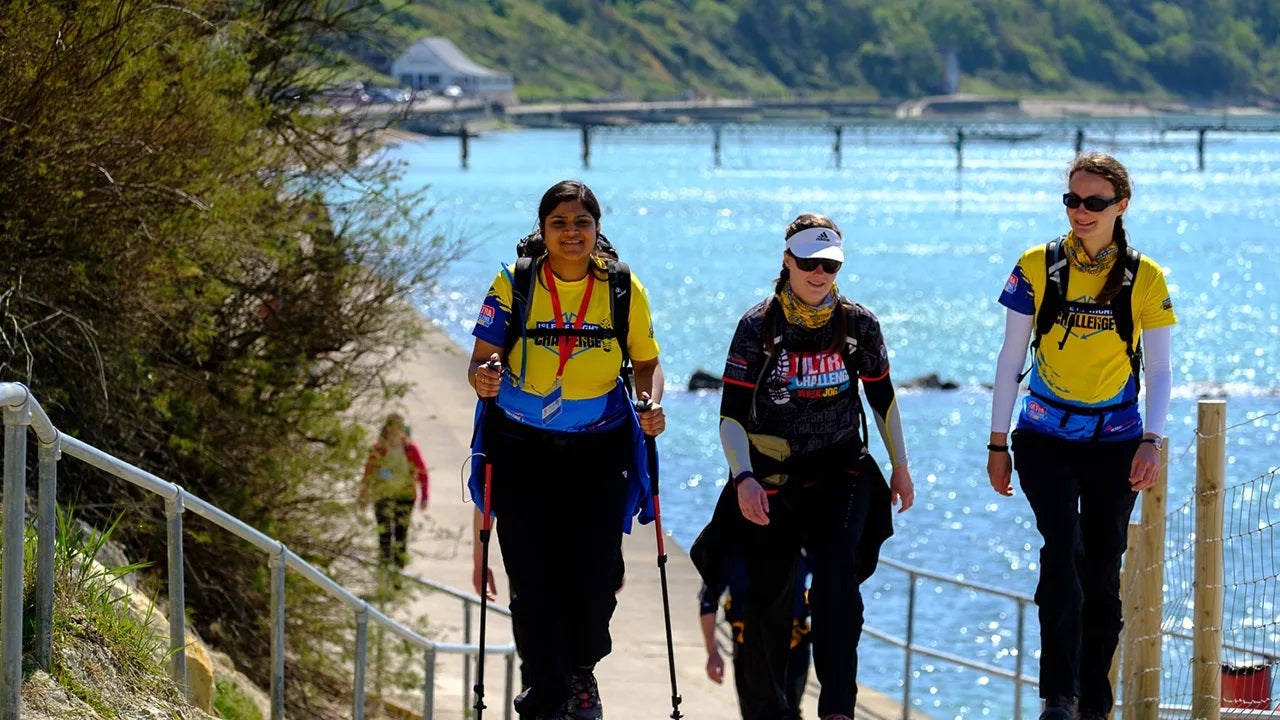 Three woman walking with the sea in the background