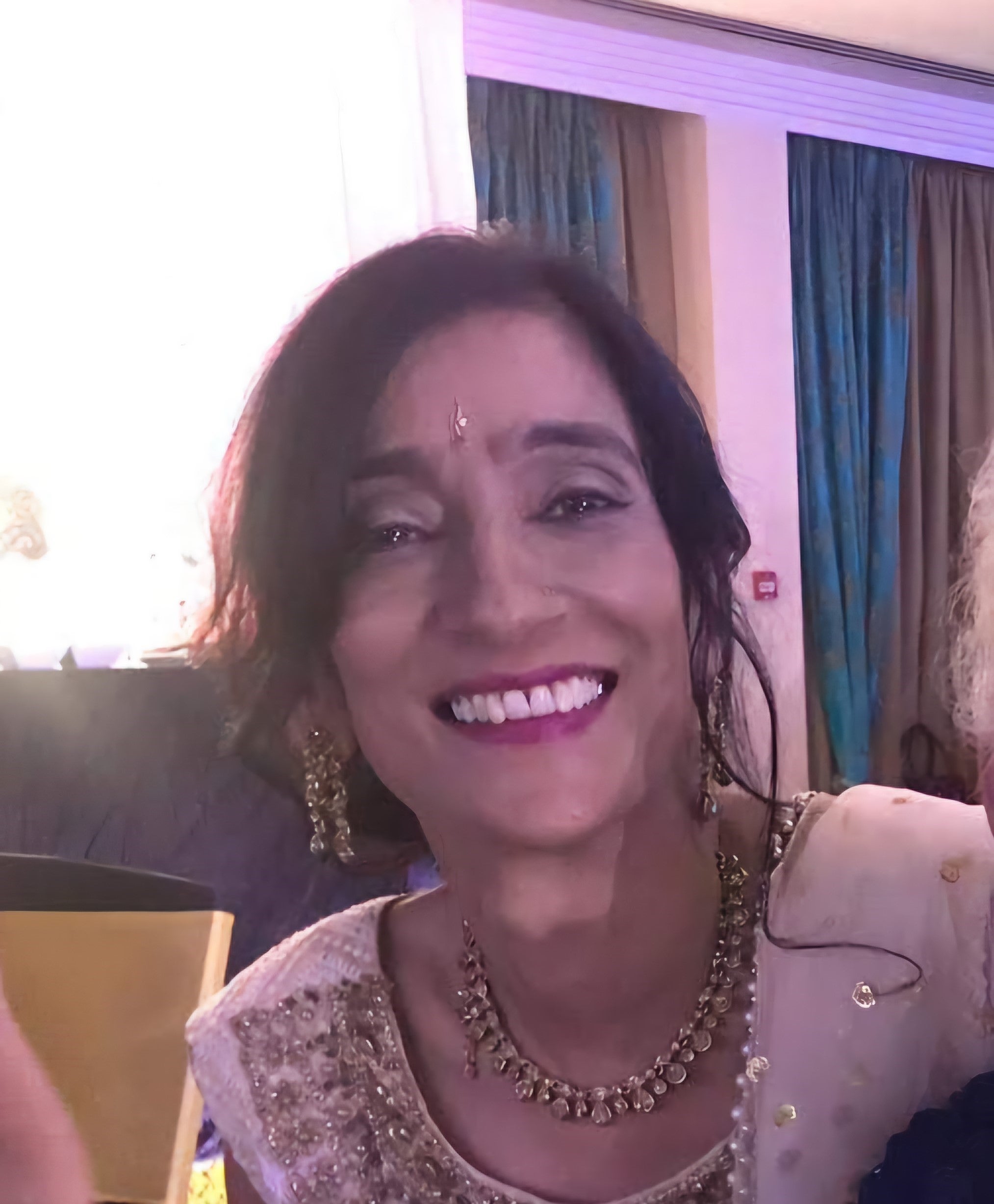 Middle aged Indian woman smiling in a sari