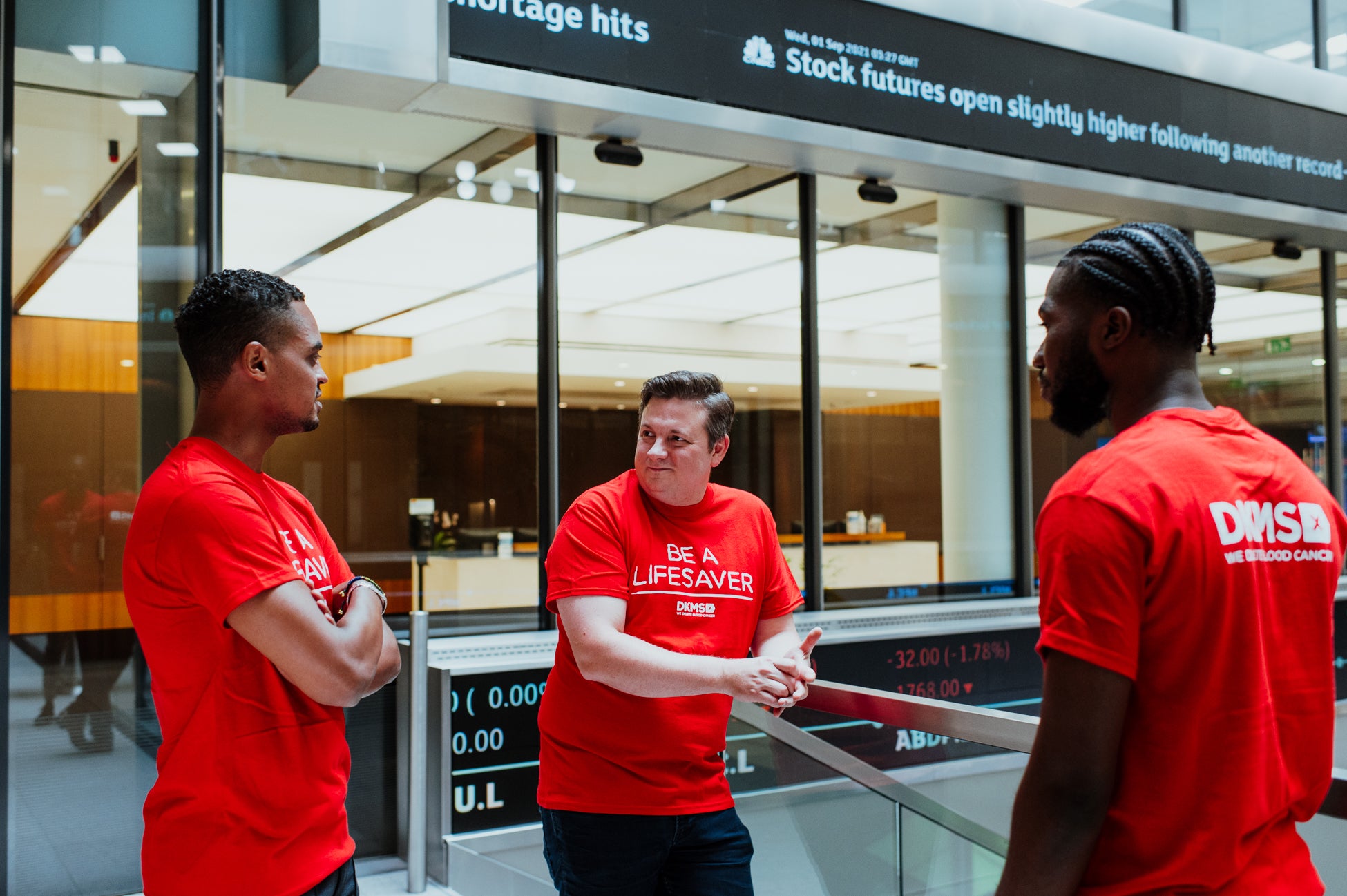 Group of people at London Stock Exchange Corporate Partnership in red DKMS t-shirts